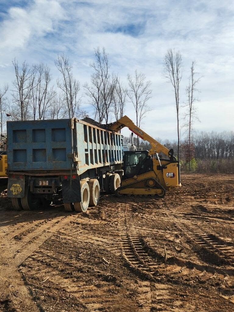 CAT compact track loader placing debris into a dump truck