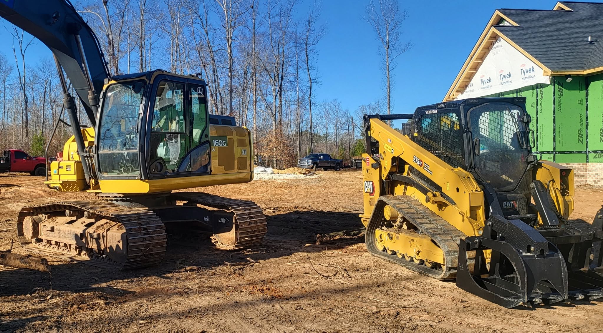 Excavator and compact track loader working together on a residential site-preparation job